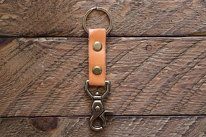 Russet handmade leather keychain with brass key ring and clip on wood