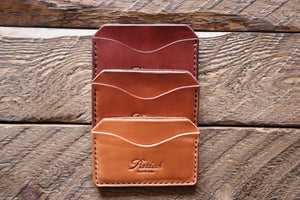 Brown handmade and hand stitched horizontal card case wallets on wood