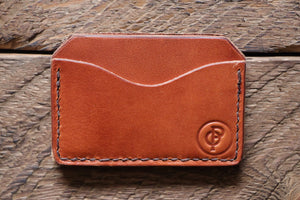 Brown handmade and hand stitched horizontal card case wallet on wood